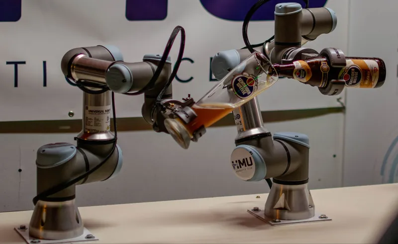 Robotic arms pouring beer into a glass