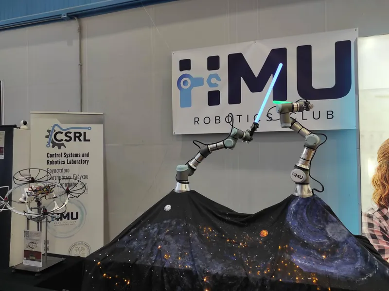 Two robotic arms duelling with light sabres