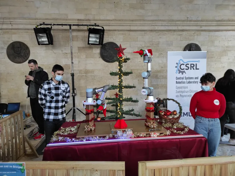 Robotic arm decorating a Christmas tree at an event